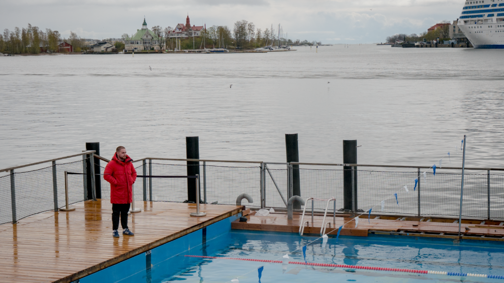 En livvakt står vid ändan av en utomhus simbassäng.