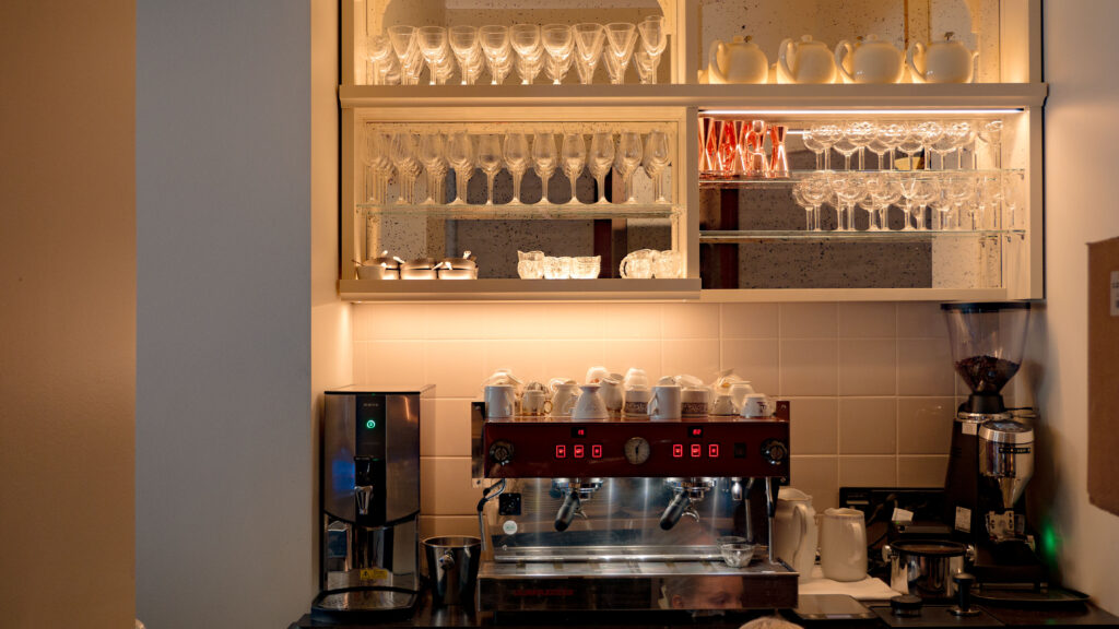 Kaffebar med blänkande espressomaskiner och rader av glas, redo för både kaffe och cocktails.